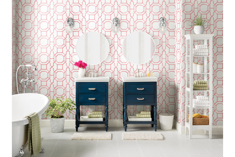 glam bathroom with two blue vanities, pink and white art deco wallpaper and white bath rugs in front of the vanities