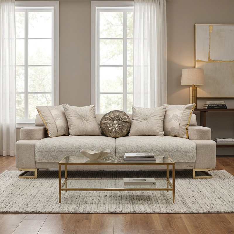 Causeuse moderne en tissu beige avec base en métal doré et coussins décoratifs