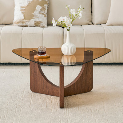 Table basse triangulaire de style rétro avec un plateau en verre trempé de couleur thé et des pieds triangulaires en panneau de fibres à densité moyenne de couleur noyer. Idéal comme table d'appoint de canapé, table de coin, table basse portable pour le salon.