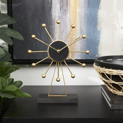 Horloge décorative dorée en métal avec base noire et cadran