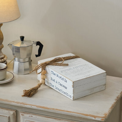 «Rustic The World Is But A Canvas To The Imagination», citation inspirante, pile de livres en bois avec perles de jute