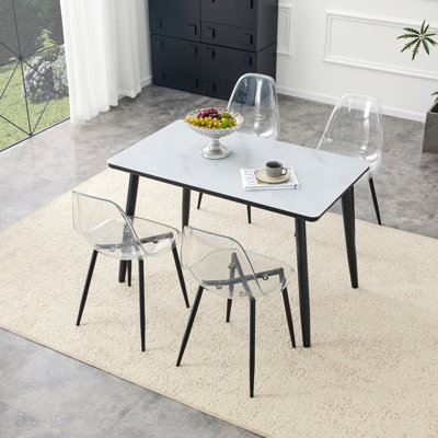 Ensemble de table et de chaises avec plateau en verre imitation marbre blanc, base en panneau de fibres à densité moyenne, pieds fuselés en métal argenté et 4 chaises en plastique transparent avec pieds en métal argenté
