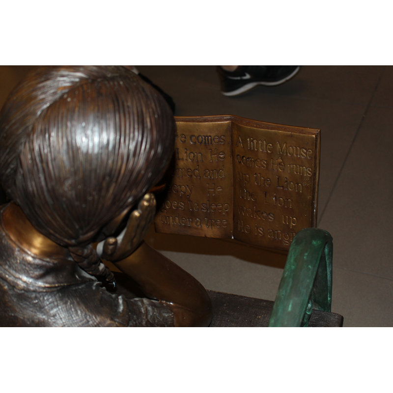 Girl laying on a bench reading a book Bronze Statue -  Size: 27"L x 39"W x 32"H