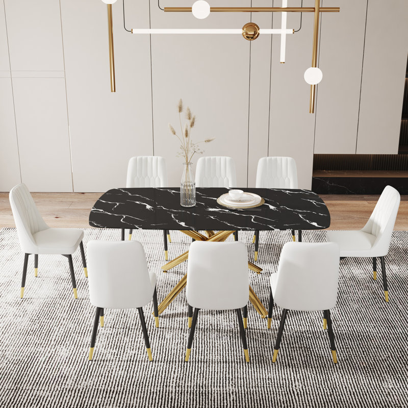 Ensemble de table et de chaises. Grande table de salle à manger rectangulaire minimaliste moderne avec plateau en verre noir imitation marbre 0,39 et pieds en métal doré, jumelée à 8 chaises en polyuréthane blanc avec pieds en métal noir.