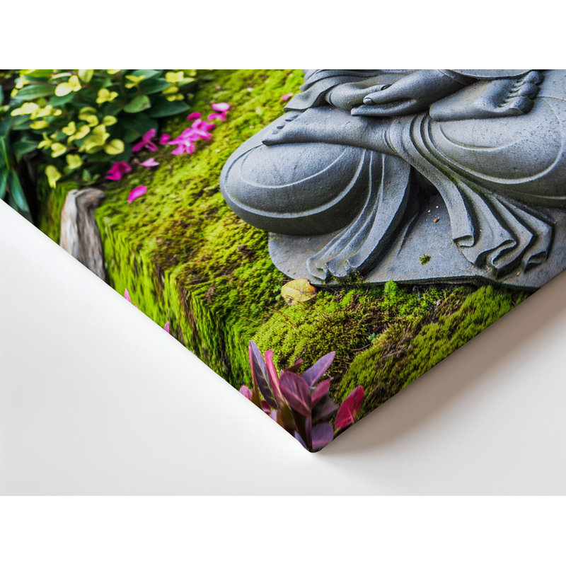 Toile, statue de Bouddha sereine posée dans une pose méditative sur un mur, galets noirs lisses entourés de mousse verte vibrante et art mural sur toile colorée