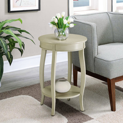 Table d'appoint ronde blanche antique avec étagère, s'harmonisant avec le décor de la pièce. Étagère en bois pour le rangement et la présentation.