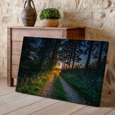 Toile, scène sereine de forêt au crépuscule, avec un chemin de chemin de terre sinueux illuminé par une lumière dorée chaude filtrant à travers la toile