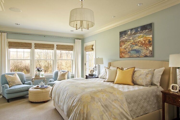 bedroom with queen bed, sitting area, and crown molding