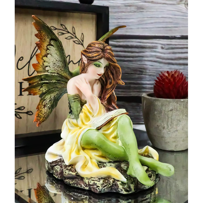 Figurine de fée sur un rat de bibliothèque