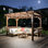 Pergola en bois avec toit en métal, ampoules et comptoirs de bar attrayants