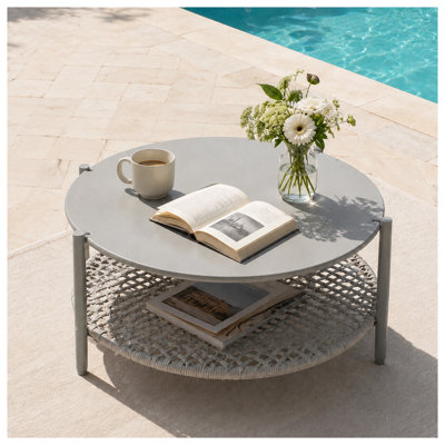 Table basse ronde d'extérieur moderne à deux niveaux, plateau en fer antirouille et étagère en rotin en PE tressé à la main, idéale pour terrasse, jardin et balcon.