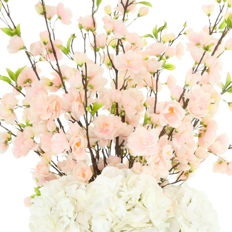 Arrangement de fleurs de cerisier et d'hortensias dans un vase en céramique