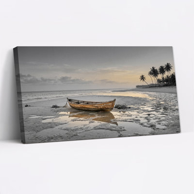 Tableau sur toile représentant un bateau en bois se reflétant dans le sable mouillé près de palmiers