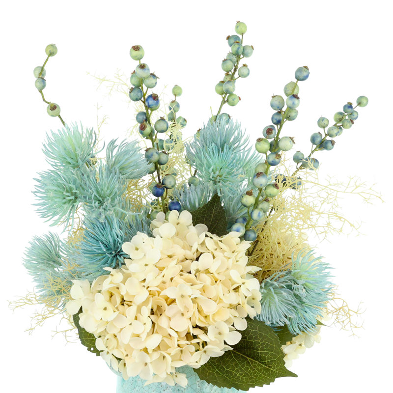 Hortensia, chardon et fougères disposés dans un vase en céramique