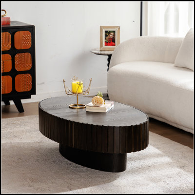 Table basse ovale avec relief fabriqué à la main et piédestal robuste, parfaite pour les salons modernes et traditionnels