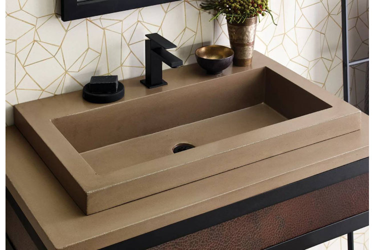 closeup of a brown trough sink with a black faucet