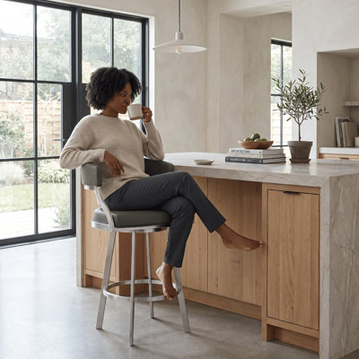 Tabouret de bar rotatif Dehn avec dossier ouvert et repose-pieds en métal et similicuir Dehn