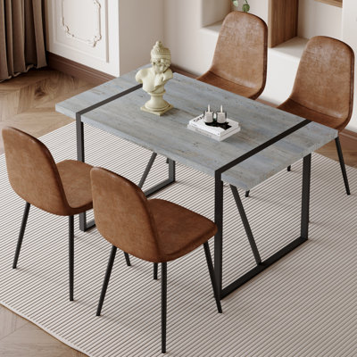 Ensemble de table et de chaises. Une table de salle à manger rectangulaire rétro minimaliste avec un dessus spécialement texturé et des pieds en métal noir, jumelée à 4 chaises douces et des pieds en métal noir, met en valeur un beau style de maison.