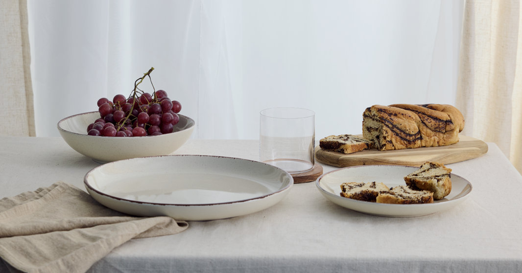 Earth & Clay dinnerware set on a neutral-toned table, featuring organic shapes and soft textures.
