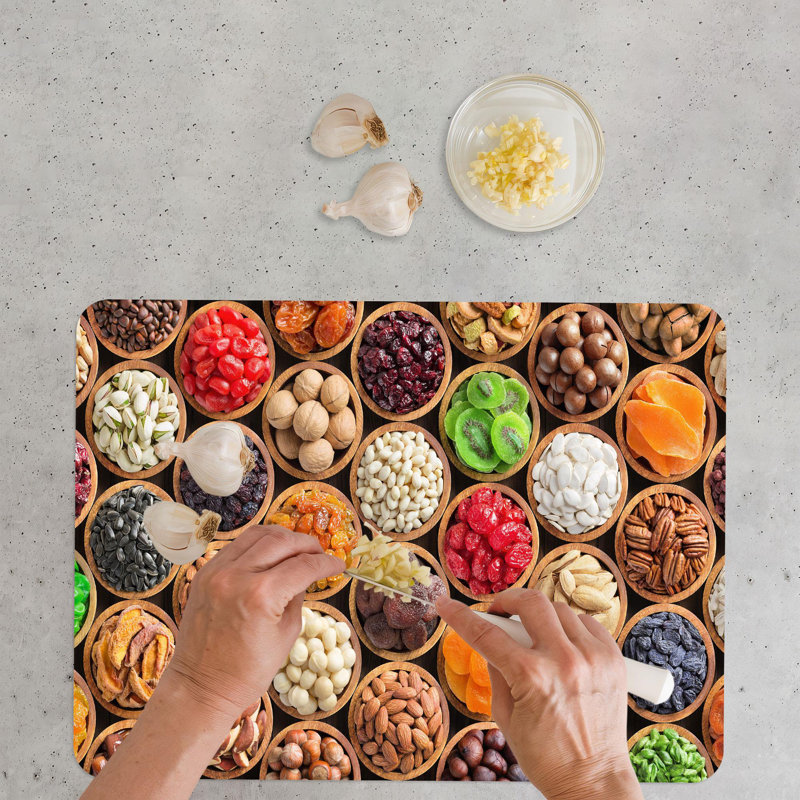 Élégante planche à découper en verre avec une représentation colorée moderne d'une planche à découper avec des fruits et des noix frais