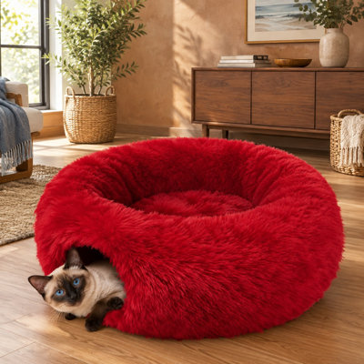 Mesurant 91 cm x 91 cm x 25 cm, ce lit tunnel de Noël rouge en peluche se plie en un tunnel/jupe de sapin rond en forme de beignet et comprend un coussin pour les chatons d'intérieur et autres petits animaux.