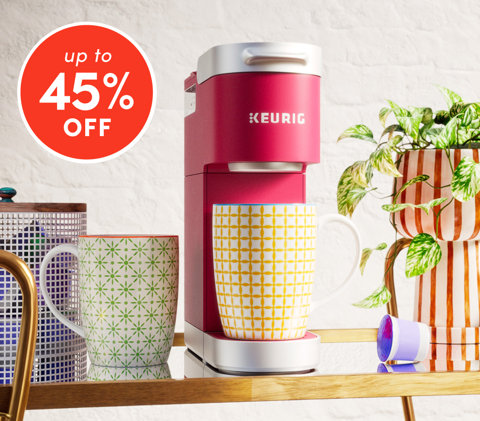 Essentiels de cuisine jusqu'à 45 % de rabais avec une cafetière Keurig rose, des tasses à motifs, des dosettes de café et une plante en pot sur un comptoir en bois