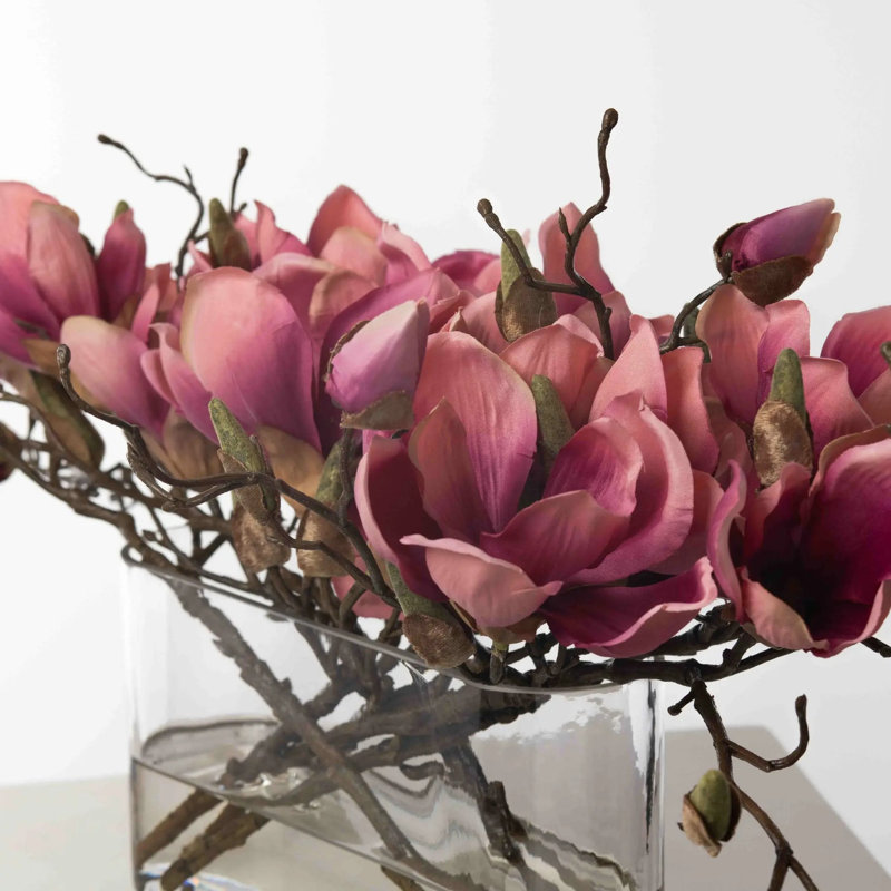 Branche de magnolia fuchsia dans un vase de poche ovale