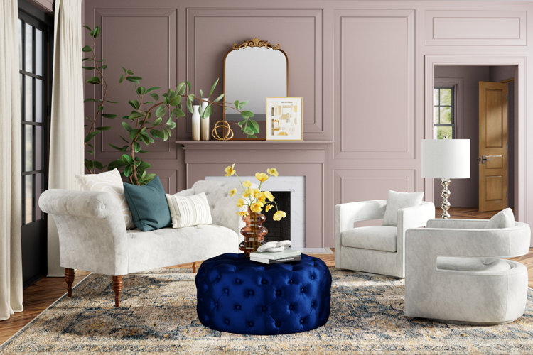 formal living room with sofa and matching armchairs and a blue ottoman