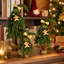 Sapins de Noël fantaisie en 3 parties, à cime incurvée, ornés de décorations dorées, de motifs en pain d'épice et de bases en toile de jute