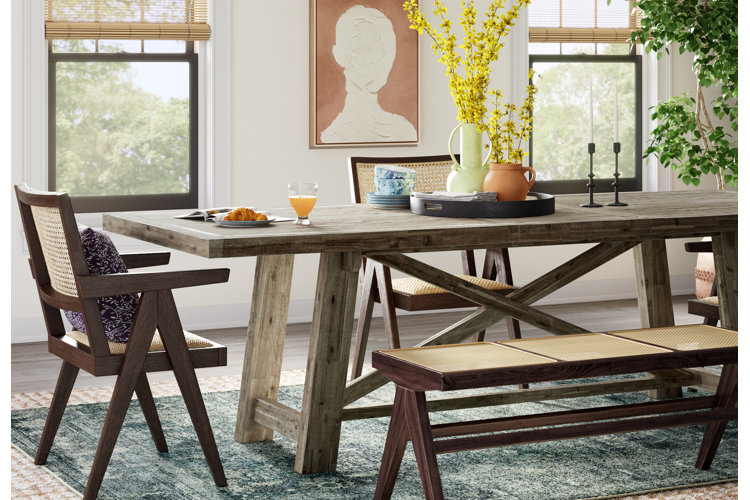 contemporary dining space with a wood dining table, a dining bench, and a dark green area rug