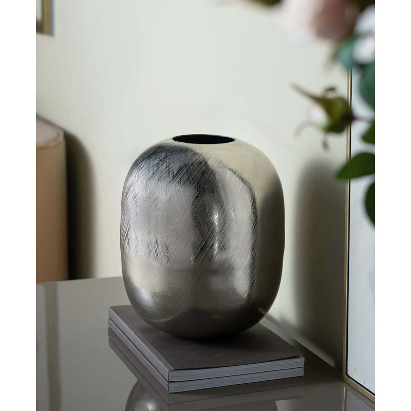 Un vase en aluminium massif léger avec une finition métallique pour faciliter le nettoyage et le déplacement, parfait pour la table de salle à manger ou le manteau de cheminée