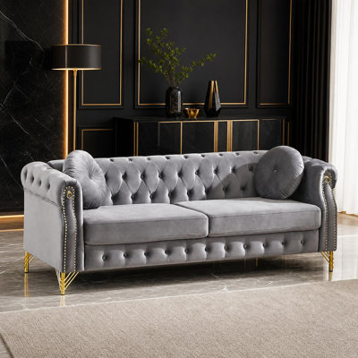 Canapé Chesterfield en velours avec anneaux décoratifs sur les accoudoirs