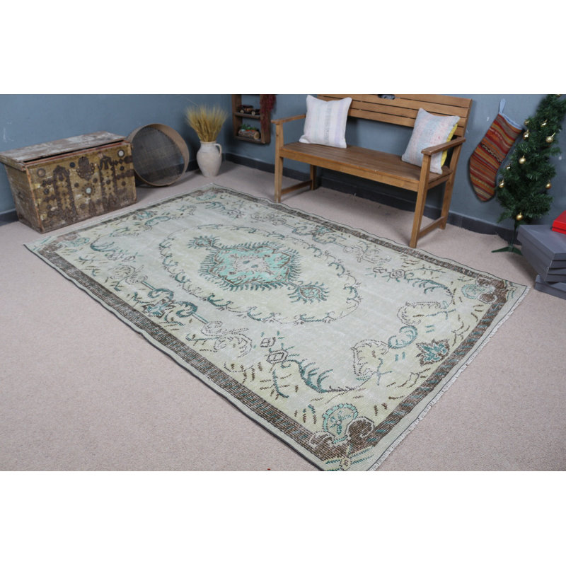 Découvrez un élégant tapis turc rétro à motifs floraux vert et beige pastel pour un décor de salon bohémien