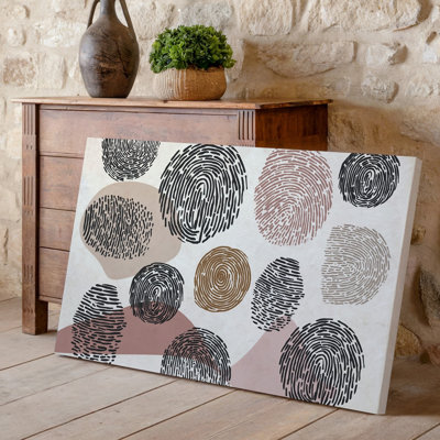 La toile crée une composition visuellement saisissante mettant en vedette un ensemble d'empreintes digitales de motifs d'art dans différentes tailles et couleurs