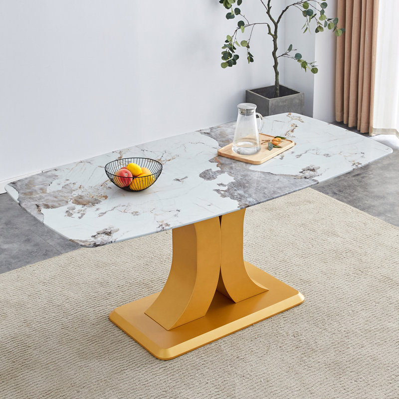 Une table de salle à manger minimaliste moderne. Plateau de table imitation verre marbré. Pieds de table en panneau de fibres à densité moyenne dorés pour la cuisine et le salon