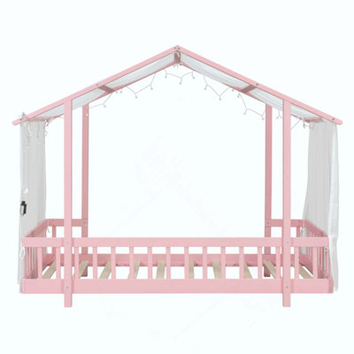 Lit plateforme avec baldaquin en tissu transparent et guirlande lumineuse