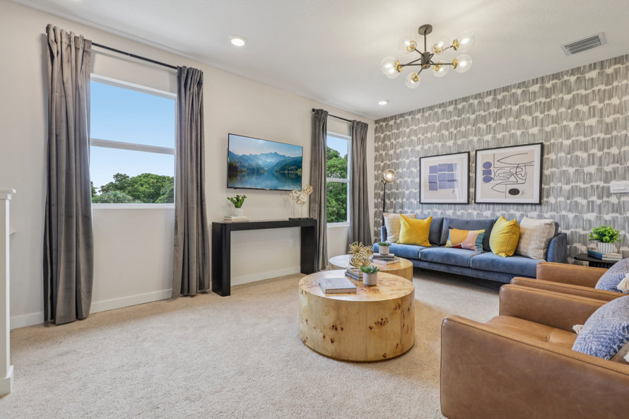 Living room with blue couch and tan armchairs.