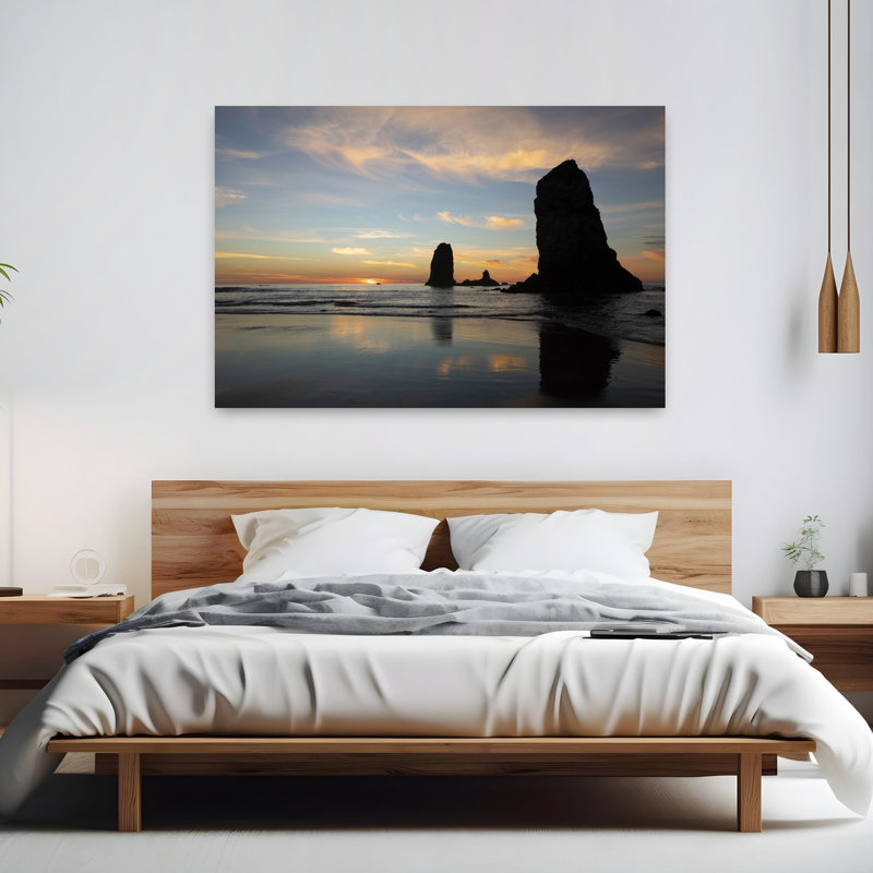 Silhouettes Of Rock Formations At Sunset At Cannon Beach Oregon USA by Dan Merkel - Wrapped Canvas Print