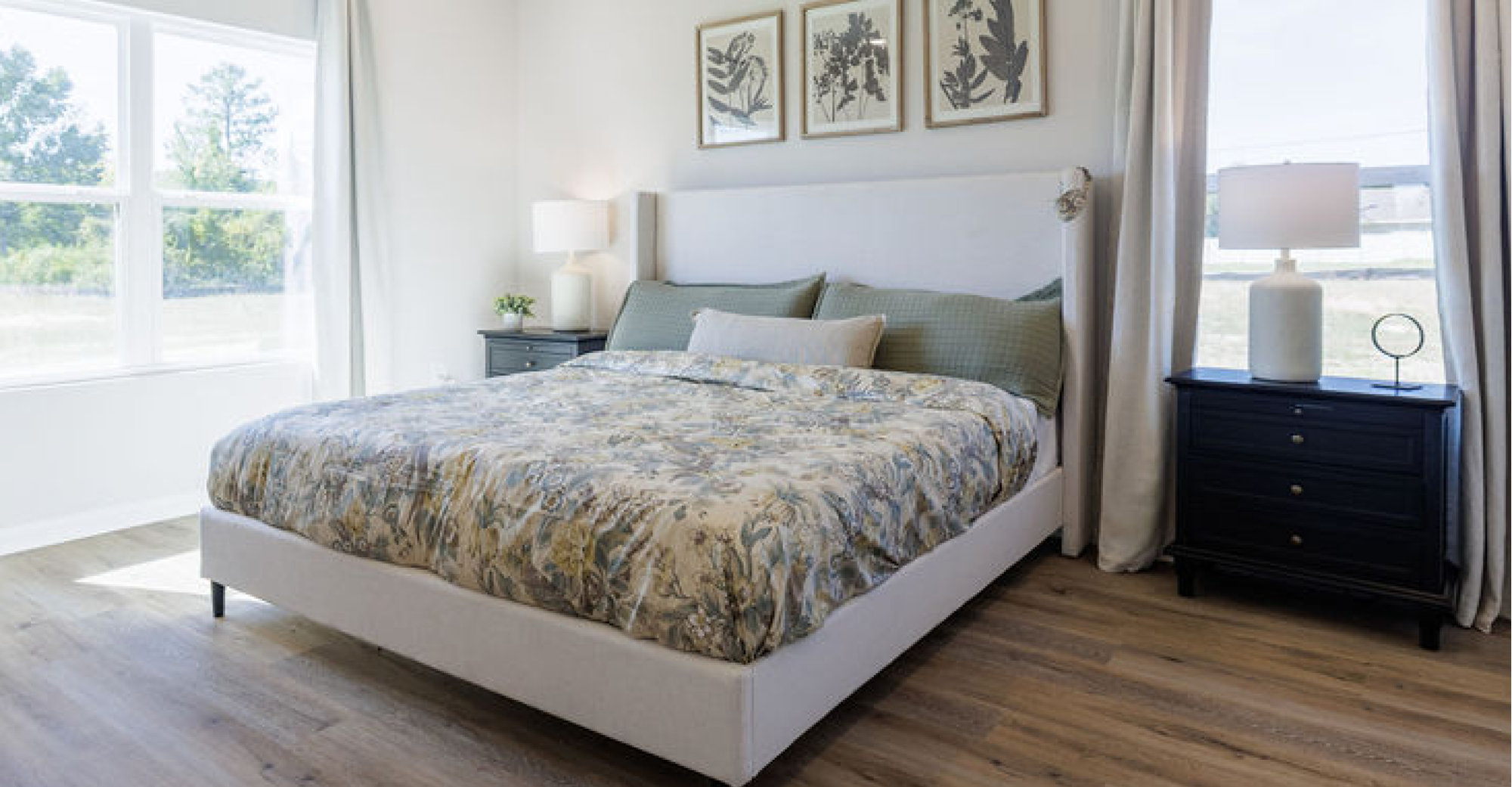 Bedroom with botanical prints above the bed.