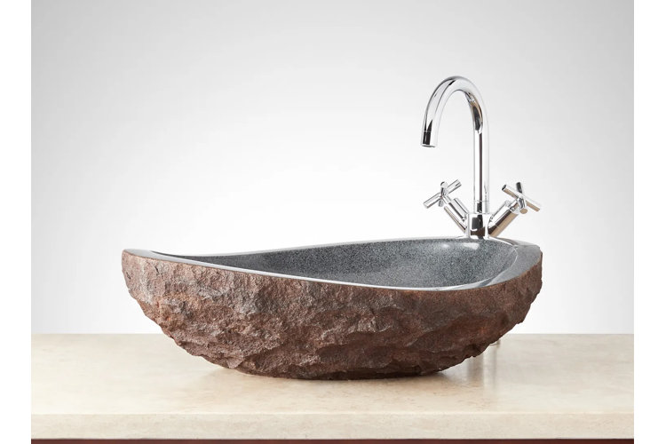 stone vessel sink atop a light wood counter