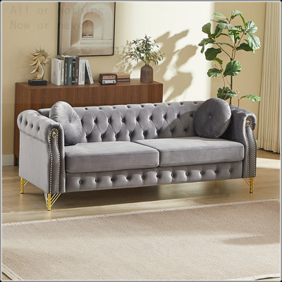 82-Inch Velvet Chesterfield sofa with two round pillows, featuring copper stud detailing and tufted button accents, with metal legs. Loop design