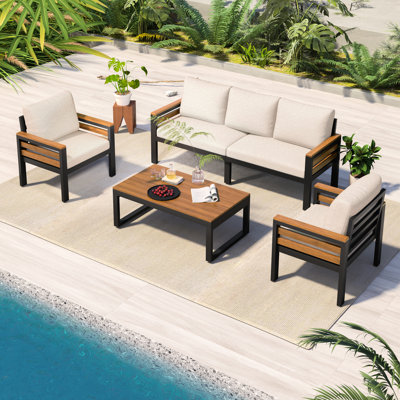Terrasse pour 5 personnes avec coussins beiges amovibles, table basse en bois et structure en métal, idéale pour les conversations dans un jardin. Convient pour un patio ou une cour arrière.
