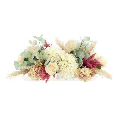 Arrangement de roses et d'eucalyptus dans un bol en bois