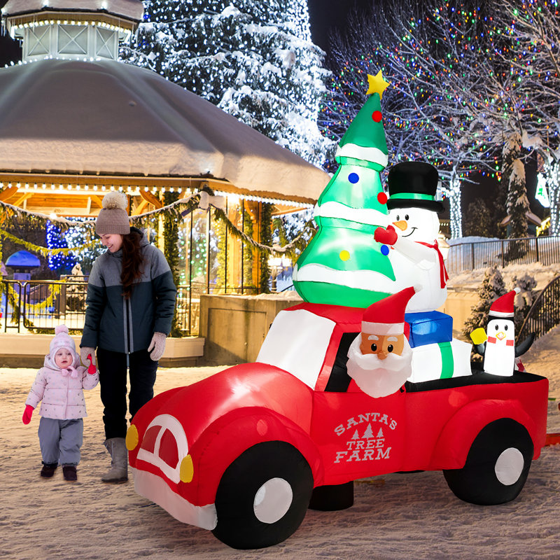 Grand père Noël conduisant une voiture gonflable