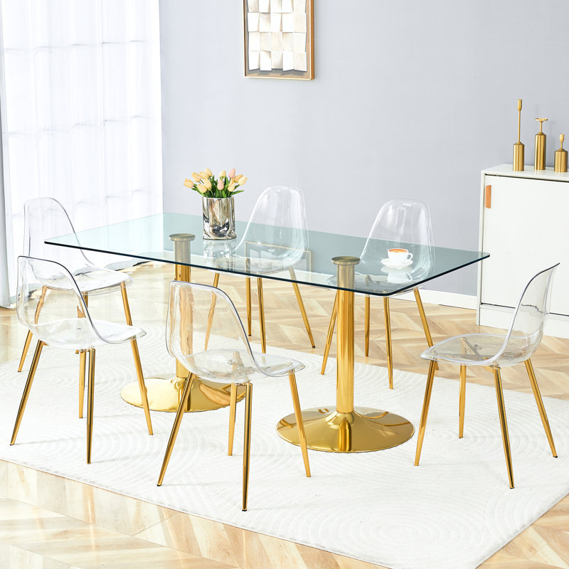Chaises en plastique transparent avec pattes en métal doré assorties à une table en verre trempé de 180 cm (71 pouces), une solution de repas stable et fonctionnelle. Table de 6 pieds, idéale pour les réunions de famille.