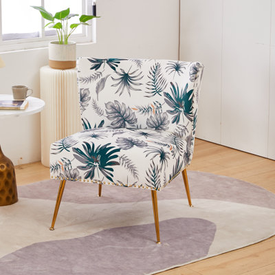 Fauteuil demi-tonneau en velours floral avec dossier courbé et pieds en métal