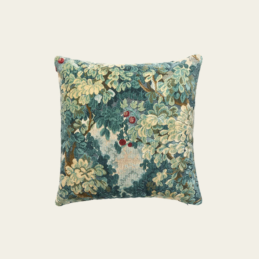 Square throw pillow featuring a textured tapestry-style pattern of green foliage and small red berries on a neutral background.