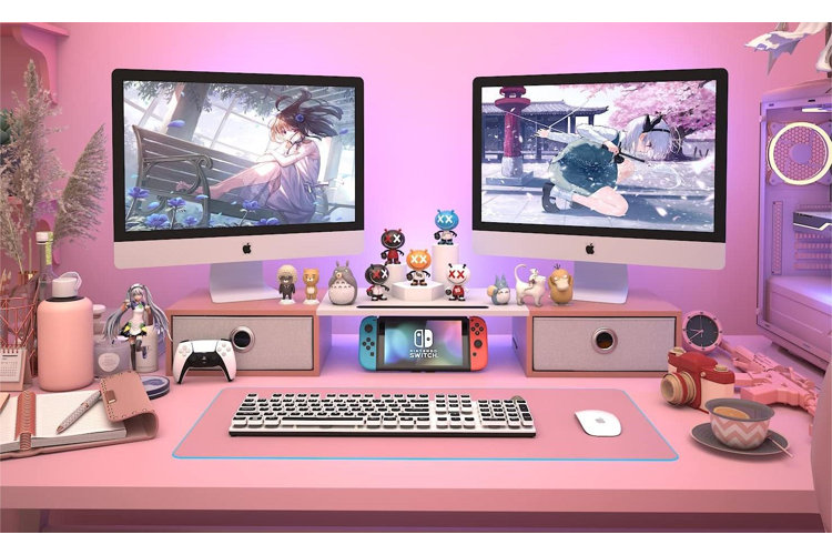 pink work desk with a large computer screen and different anime character toys displayed on the top