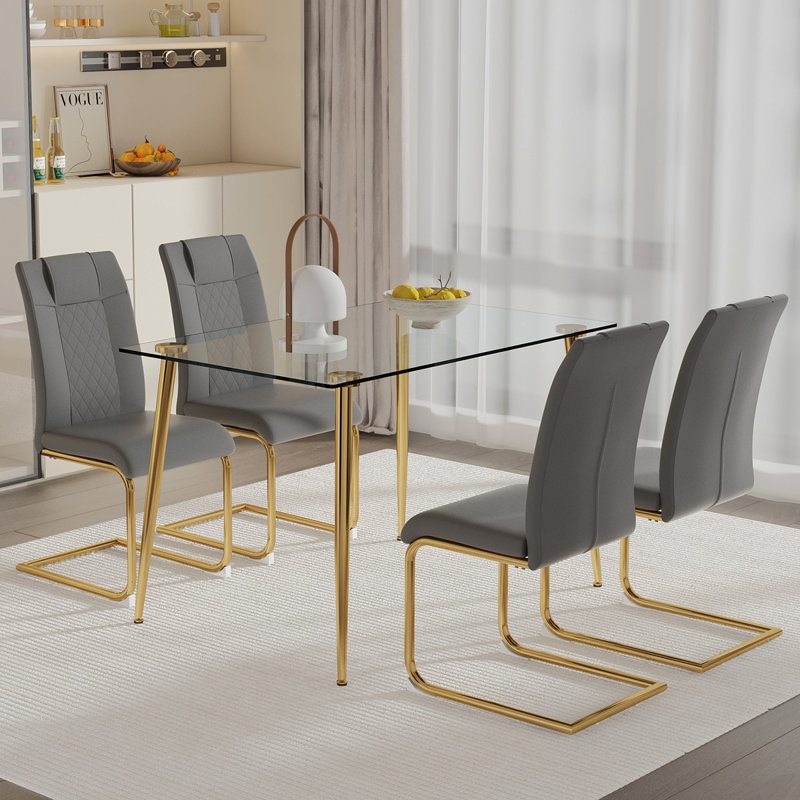 Ensemble de table et de chaises. Table de salle à manger rectangulaire avec plateau en verre trempé et pieds en métal plaqué or. Combinée avec 4 chaises gris foncé avec pieds en métal doré. Lumière moderne de luxe. W1151S03790