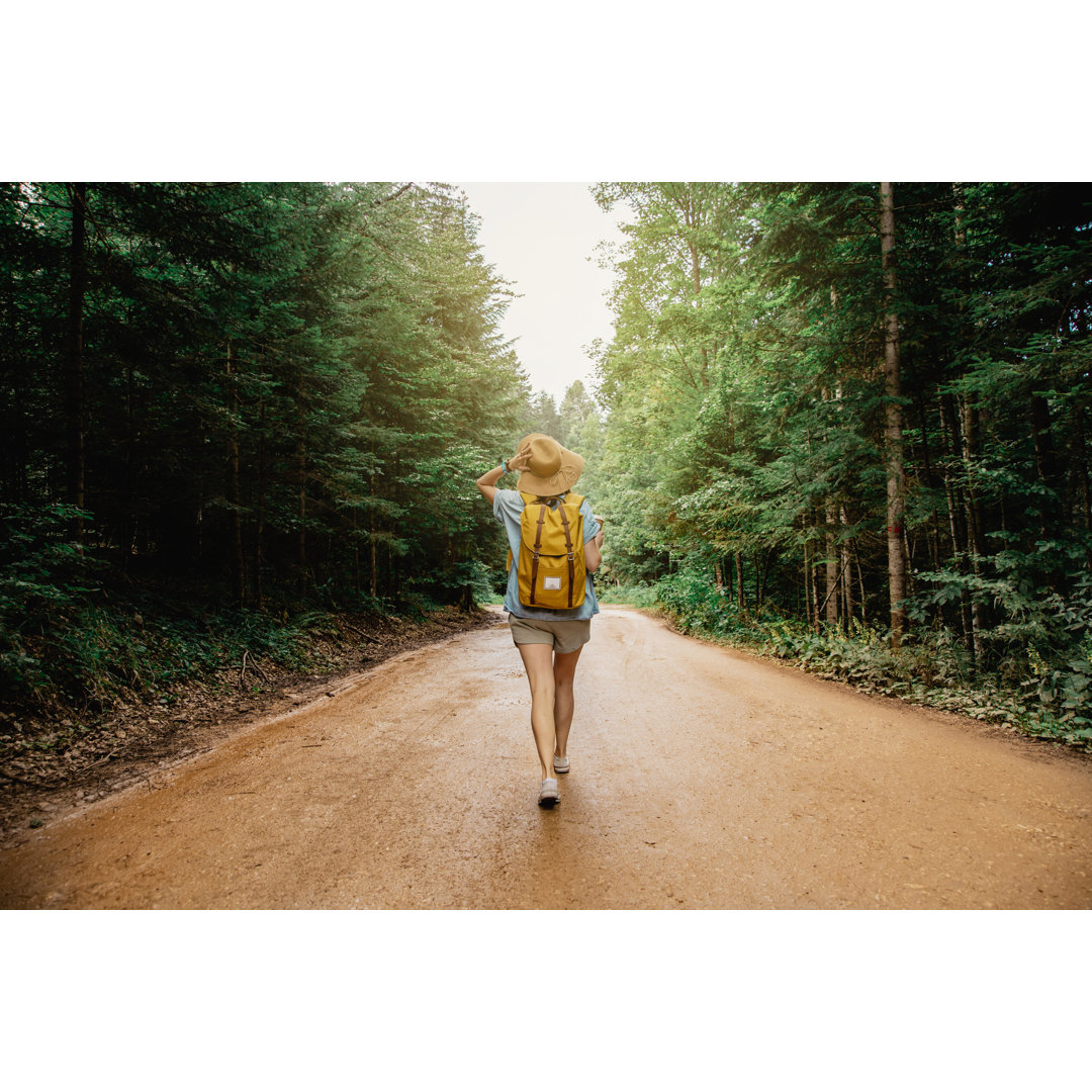 Frau mit Rucksack beim Wandern im Wald